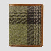 A bi-fold wallet with a combination of leather and tweed material, featuring multiple card slots, a clear ID slot, a note sleeve, and a push popper closure.