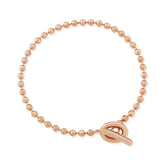 Rose gold beaded bracelet with a clasp on a white background