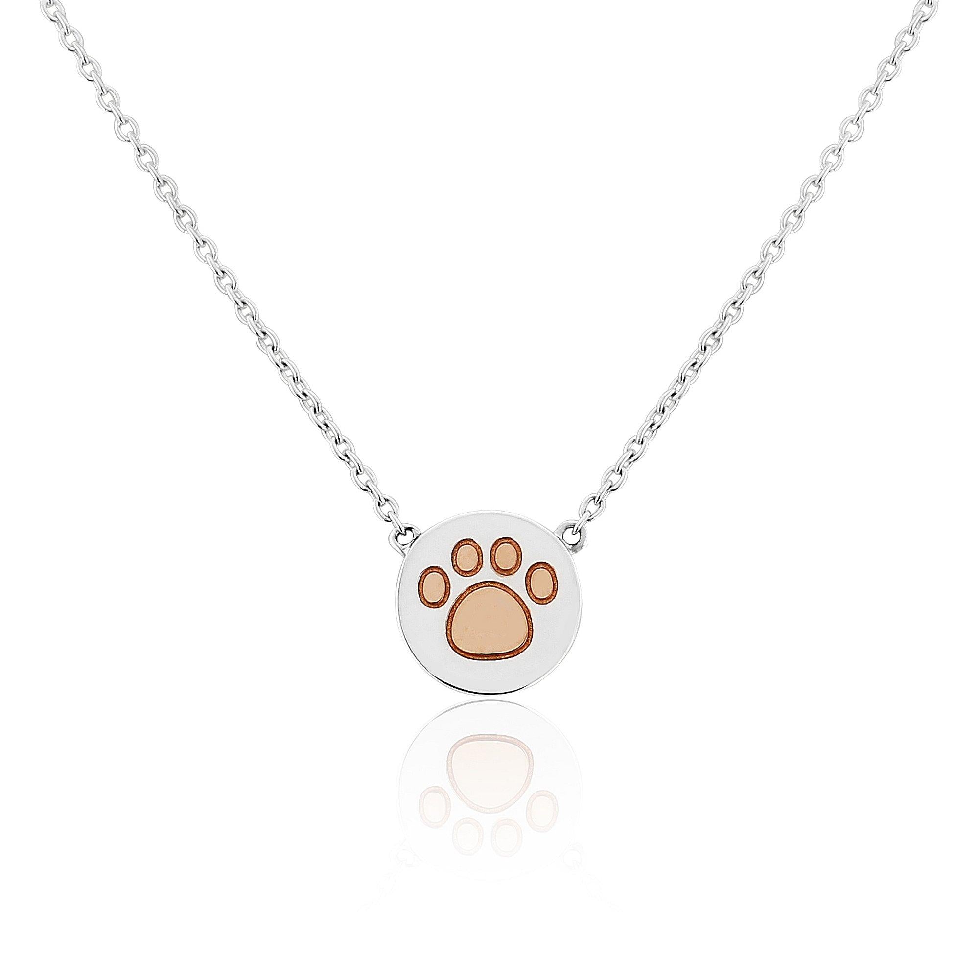 A sterling silver pendant with a rose gold paw print design on a disc, attached to a chain.