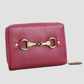 A compact pink leather purse with a metallic snaffle detail on the front, zipper closure, and a leather tassel.