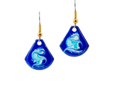 Blue earrings with white designs on a white background