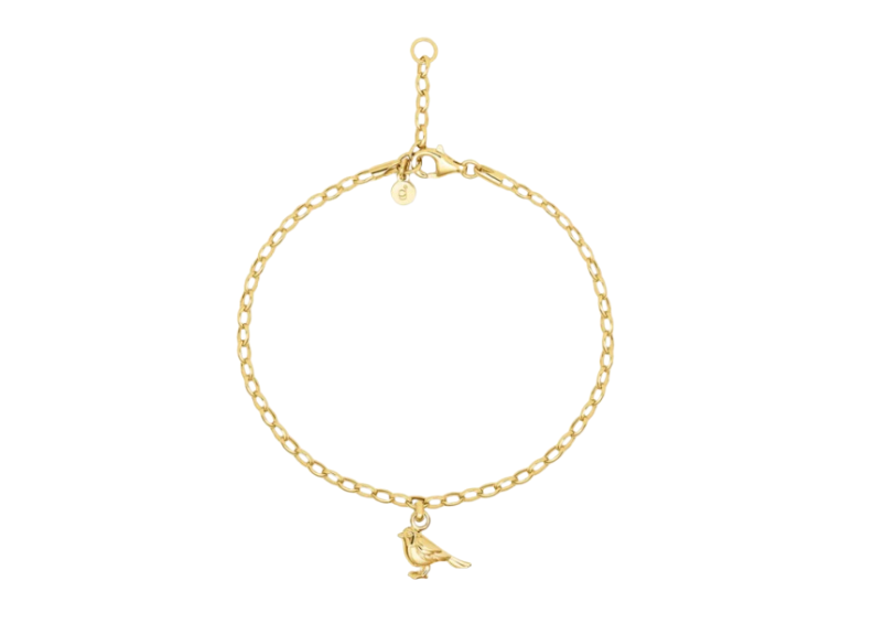 Gold bracelet with a small bird charm on a white background