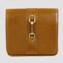 A tan colored, equestrian inspired side bag made from buffalo leather with a metal buckle closure.