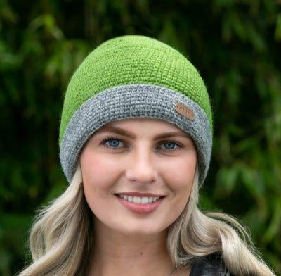 A woman wearing a green and gray knit turn up cap.