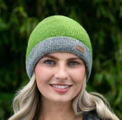 A woman wearing a green and gray knit turn up cap.