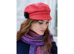 A woman wearing a red tweed newsboy hat with a black embellishment on the brim, paired with a purple scarf.