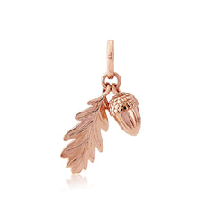 A rose gold charm featuring an acorn and leaf design.