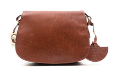 A classic tan saddle bag with rounded edges, an adjustable shoulder strap, and a zippered central pocket, hand made in Ireland.
