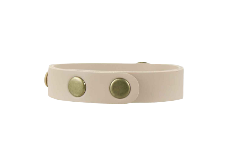 Beige dog collar with two gold buttons on a white background