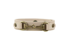 Beige leather bracelet with brass horse bit design on a white background