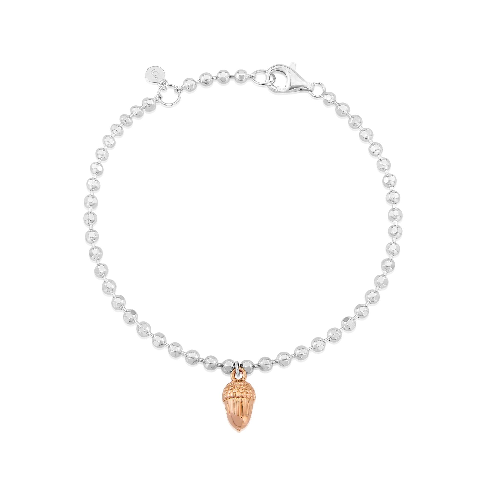 A sterling silver bracelet with rose gold beaded details and an acorn charm, adjustable in length.