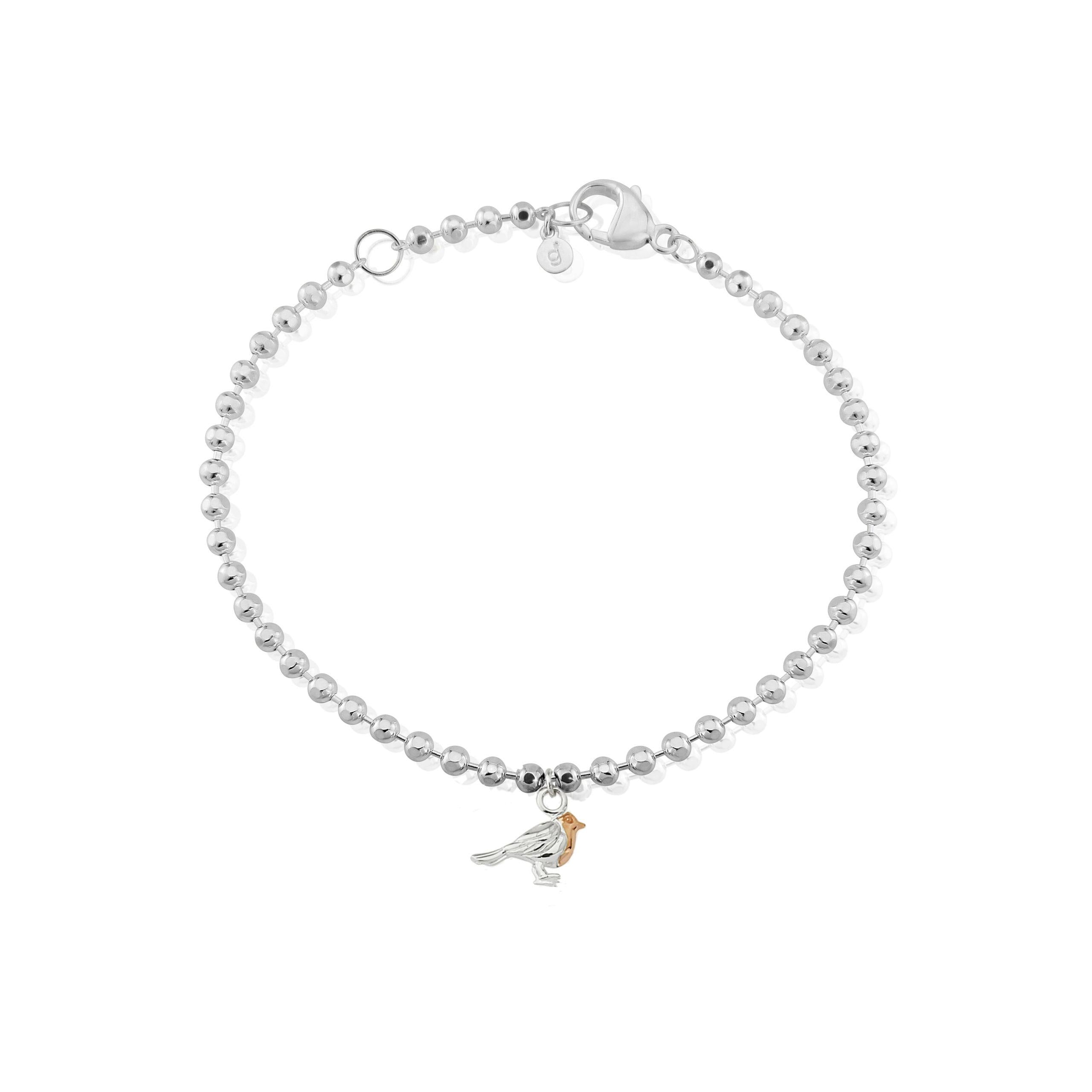 A sterling silver bracelet with small beads, featuring a rose gold beaded chain and a small charm of a robin breast, presented against a white background.