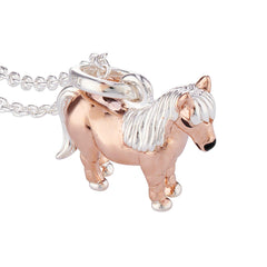 A sterling silver pendant in the shape of a Shetland pony with a rose gold vermeil finish on the body, attached to a silver chain.
