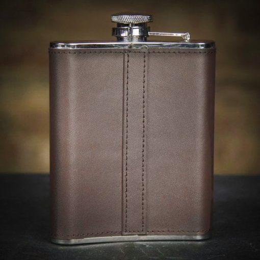 brown leather whiskey flask on a black surface