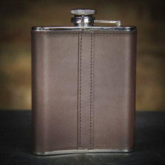 brown leather whiskey flask on a black surface