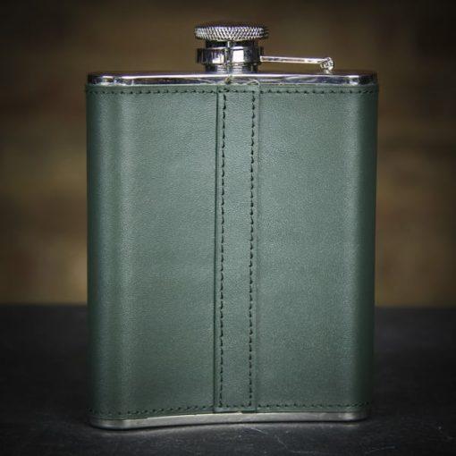 green whiskey flask on a black surface